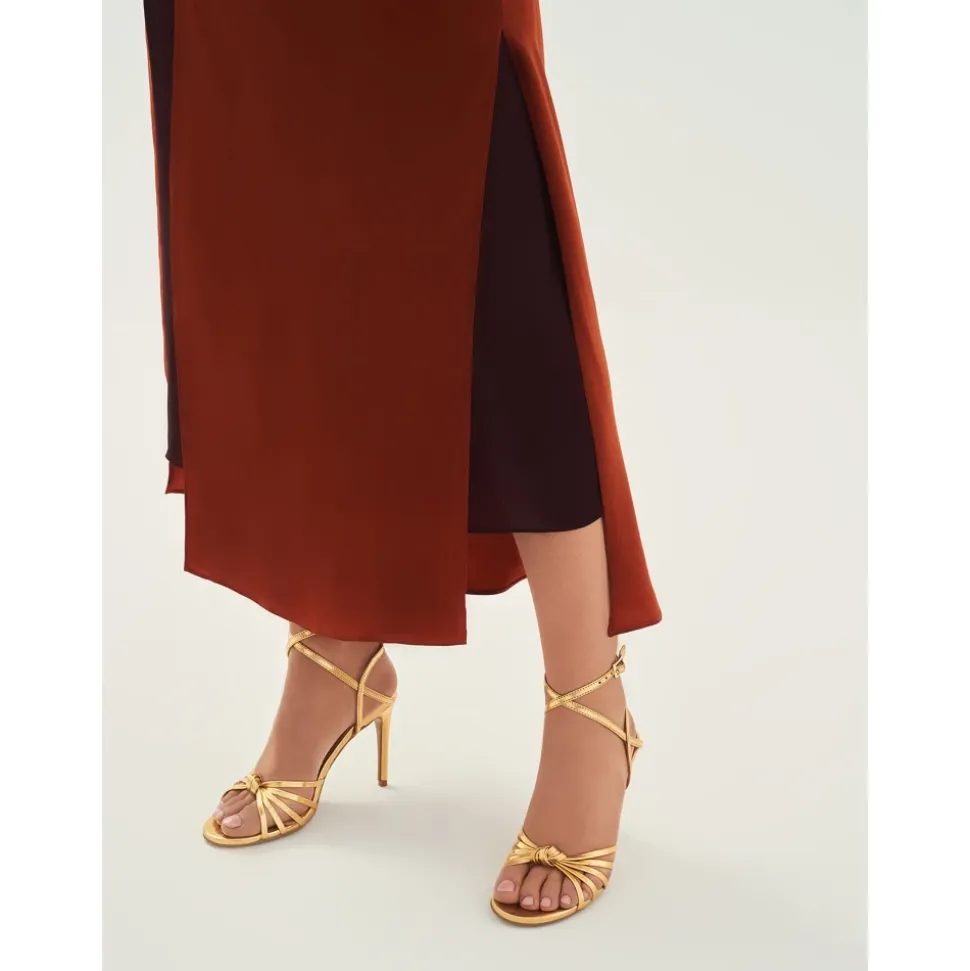 Elegante goldene Sandalen mit schrägen Riemen