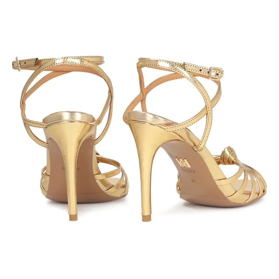 Elegante goldene Sandalen mit schrägen Riemen